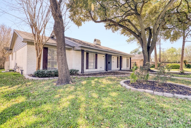 single story home featuring brick siding, a chimney, and a front lawn