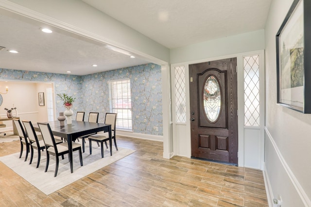 foyer with recessed lighting, baseboards, wood finished floors, and wallpapered walls