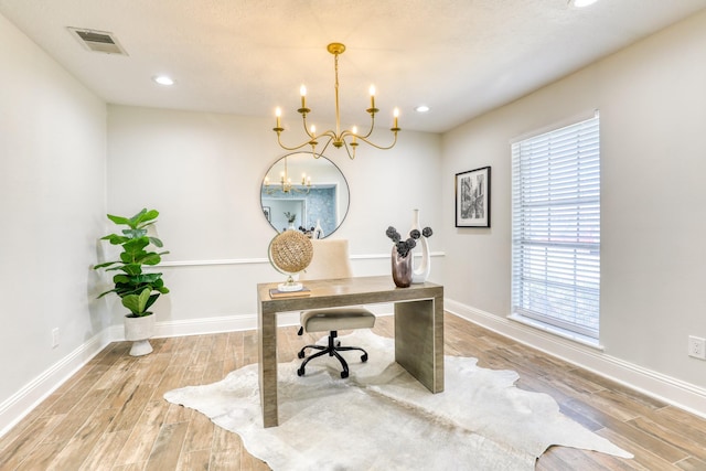 office space with baseboards, visible vents, a chandelier, and light wood-type flooring