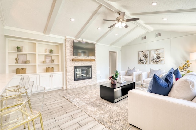 living area with wood finish floors, visible vents, lofted ceiling with beams, a textured ceiling, and a stone fireplace