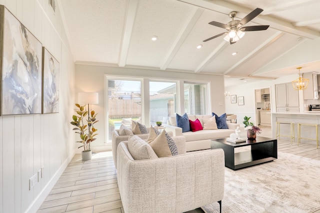 living area featuring vaulted ceiling with beams, ceiling fan with notable chandelier, visible vents, and wood finish floors