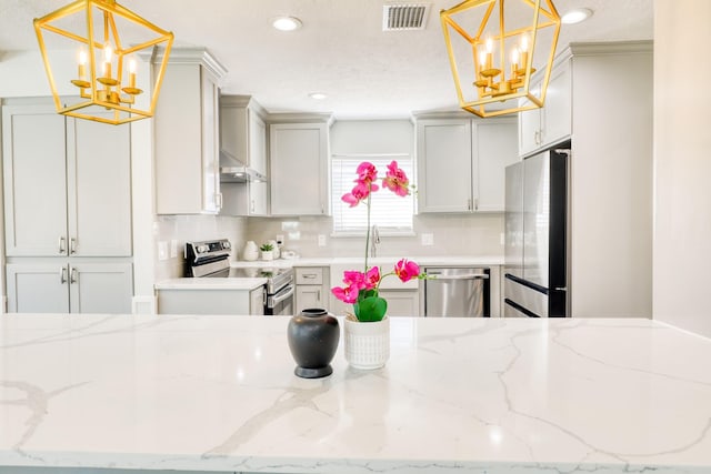 kitchen featuring decorative backsplash, visible vents, appliances with stainless steel finishes, and a chandelier