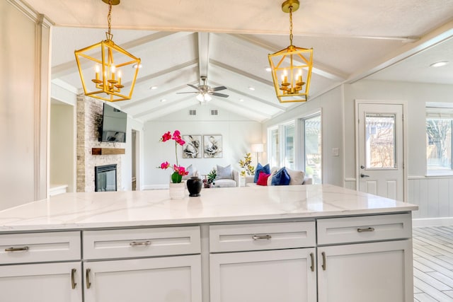 kitchen featuring open floor plan, lofted ceiling with beams, and an inviting chandelier