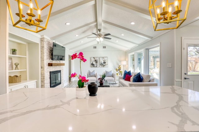 living room featuring a stone fireplace, built in features, vaulted ceiling with beams, and a textured ceiling