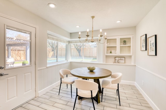 dining area featuring wood finish floors, recessed lighting, a chandelier, and wainscoting