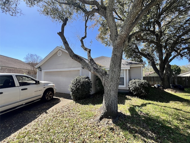 view of front of property with a garage, a front lawn, and fence