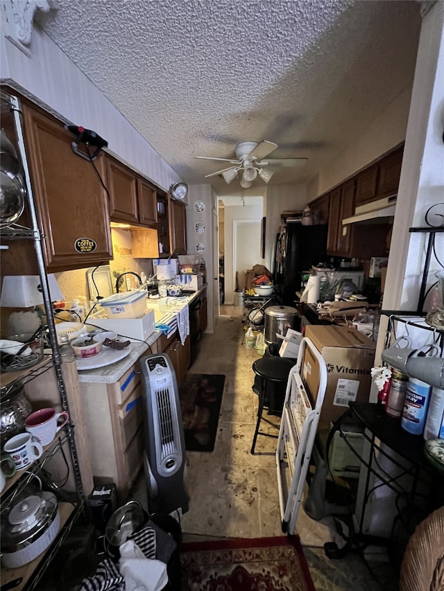 kitchen with ceiling fan, light countertops, and a textured ceiling