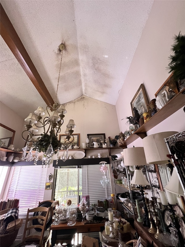 dining space with a textured ceiling and lofted ceiling with beams