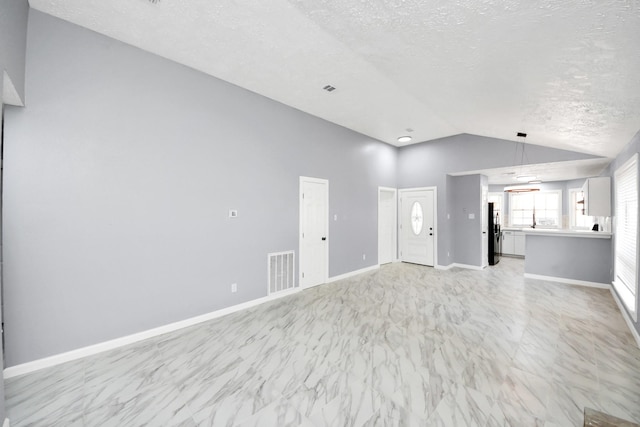 unfurnished living room with baseboards, visible vents, lofted ceiling, a textured ceiling, and marble finish floor