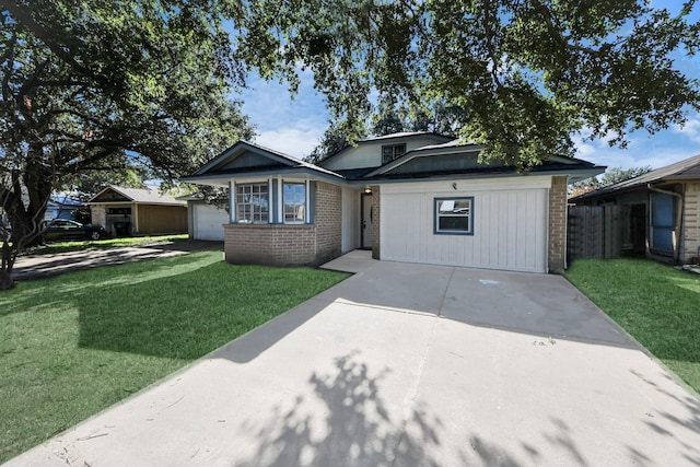 view of front of house featuring a garage, a front lawn, brick siding, and driveway