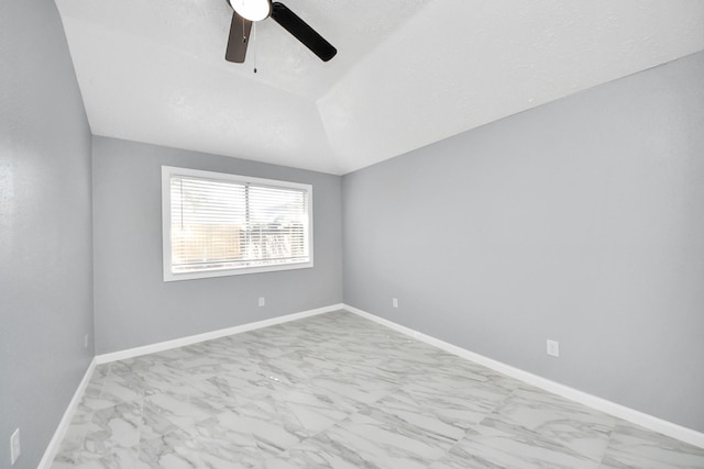 spare room featuring marble finish floor, lofted ceiling, baseboards, and ceiling fan