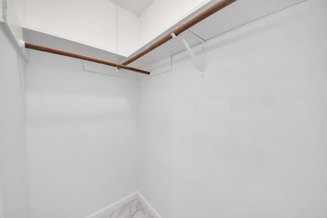 spacious closet with attic access and marble finish floor