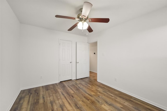 unfurnished bedroom with ceiling fan, baseboards, and wood finished floors