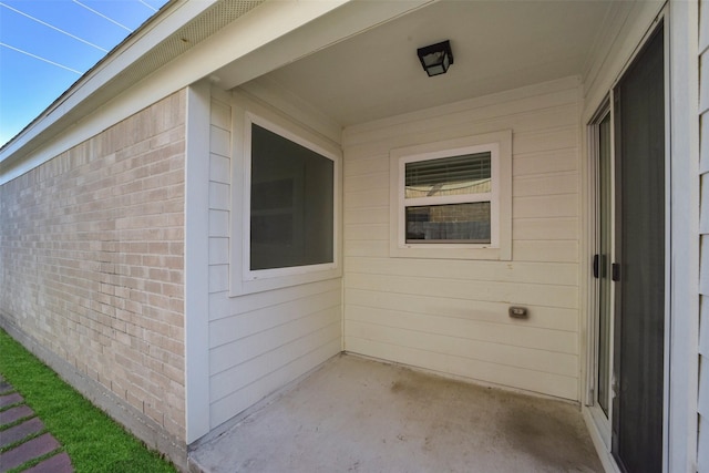 doorway to property featuring brick siding