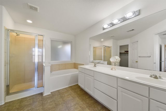 bathroom with a bath, visible vents, a shower stall, and a sink