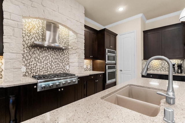 kitchen featuring wall chimney range hood, stainless steel gas cooktop, ornamental molding, decorative backsplash, and a sink