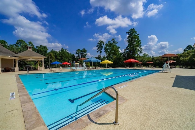 community pool with a gazebo and a patio