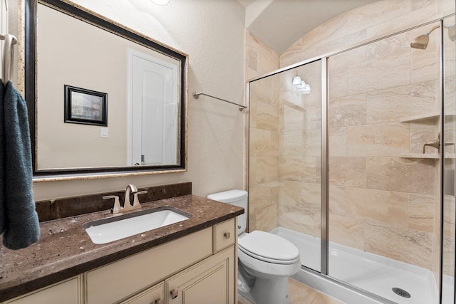 bathroom with vanity, toilet, and a stall shower