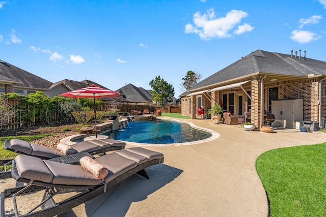 view of swimming pool featuring a pool with connected hot tub, a fenced backyard, and a patio area