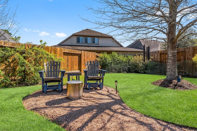 view of yard with a fenced backyard and an outdoor fire pit