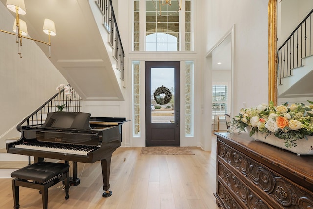 entryway with stairs, a high ceiling, and wood finished floors