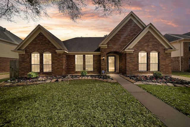 view of front of house with brick siding and a front lawn