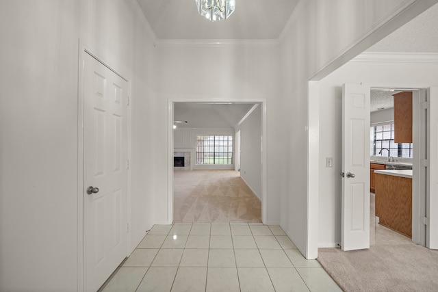 hall featuring crown molding, light colored carpet, a wealth of natural light, and a sink