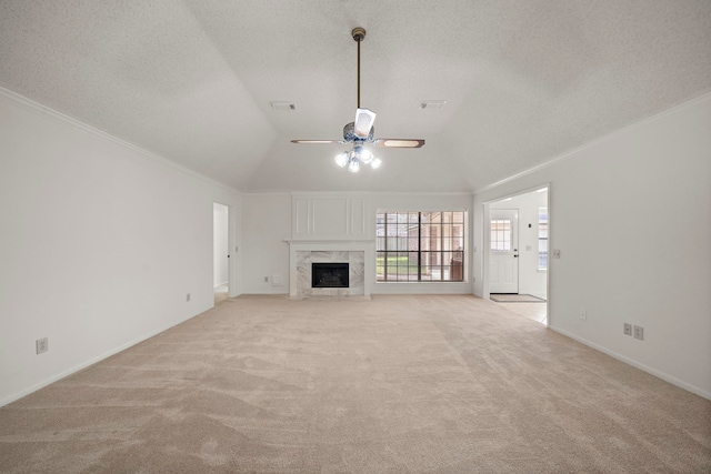 unfurnished living room featuring visible vents, a premium fireplace, ornamental molding, a textured ceiling, and light colored carpet