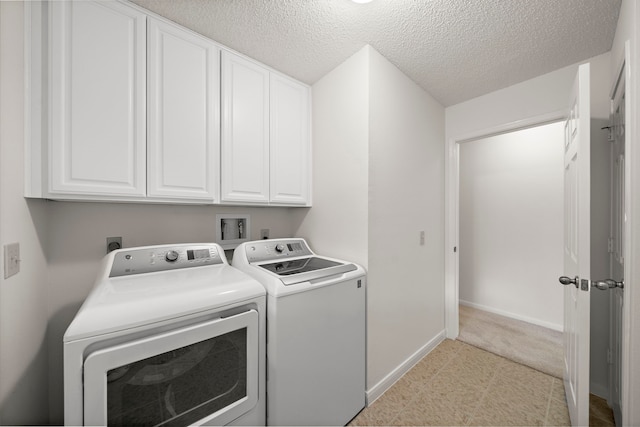 laundry area with baseboards, cabinet space, a textured ceiling, and independent washer and dryer