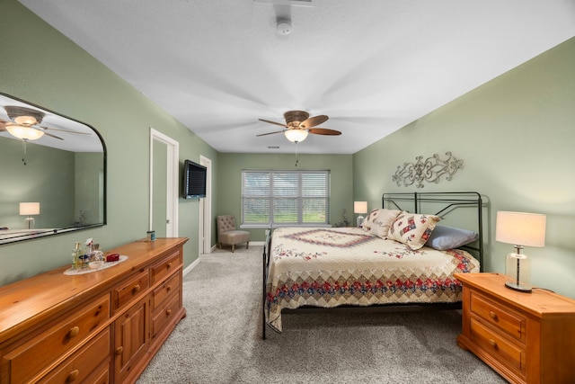 bedroom with light colored carpet, baseboards, and ceiling fan