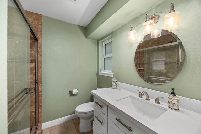 bathroom with baseboards, toilet, a stall shower, and vanity