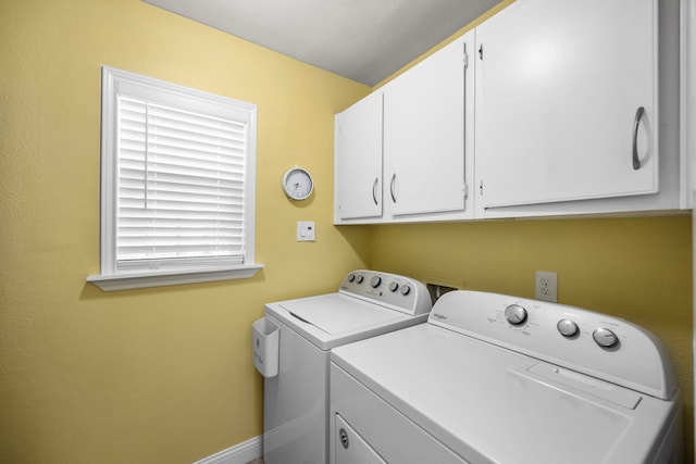 laundry room with washing machine and clothes dryer, cabinet space, and baseboards