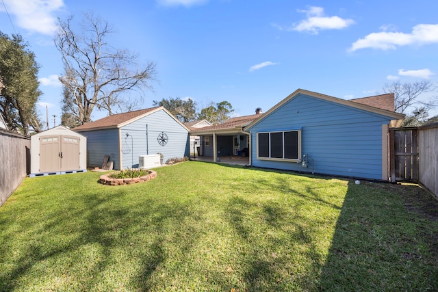 back of property featuring a lawn, a patio, a fenced backyard, a shed, and an outdoor structure