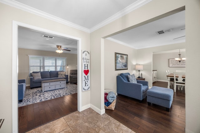 living area featuring visible vents, ornamental molding, ceiling fan with notable chandelier, and hardwood / wood-style floors