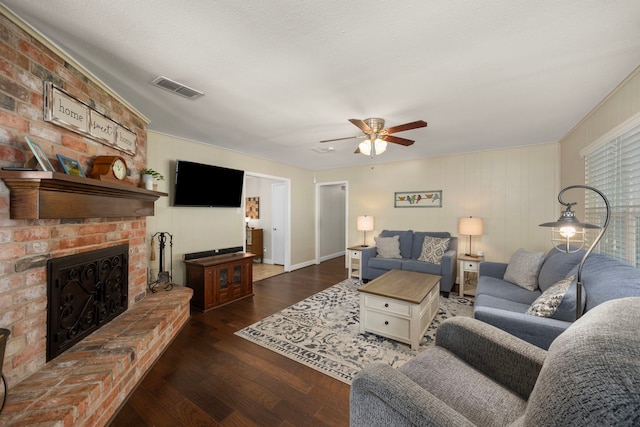 living area featuring visible vents, a fireplace, ceiling fan, and wood finished floors