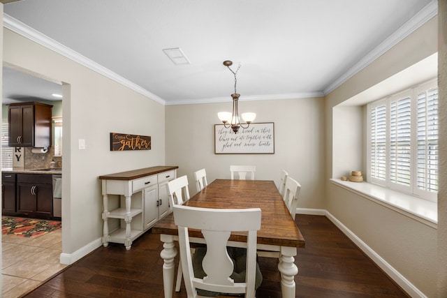 dining area with dark wood finished floors, crown molding, and baseboards