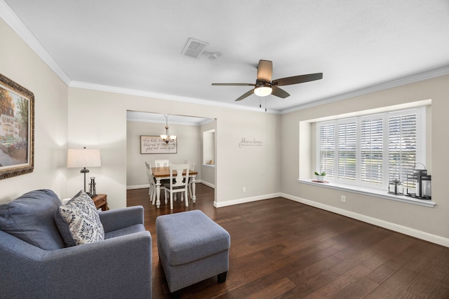 living area featuring dark wood finished floors, baseboards, visible vents, and ornamental molding