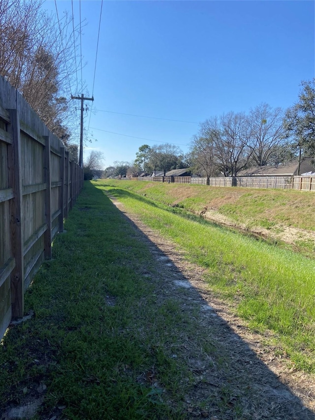 view of yard featuring a rural view and fence