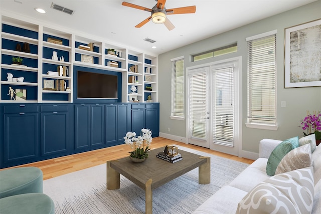 living area featuring visible vents, light wood-type flooring, and baseboards