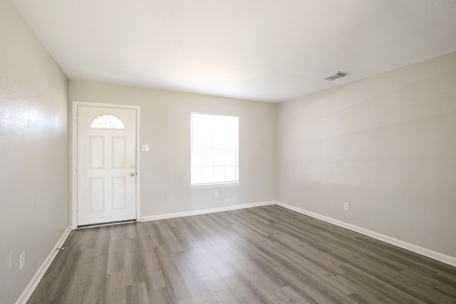 entryway with dark wood finished floors, baseboards, and visible vents