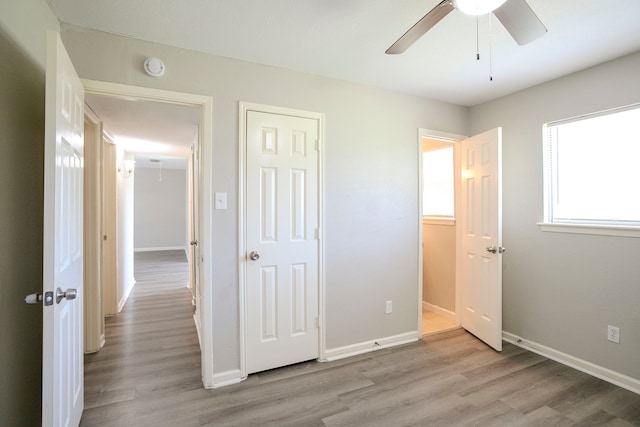 unfurnished bedroom featuring ceiling fan, light wood-type flooring, and baseboards