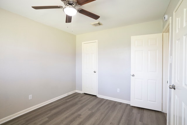 unfurnished bedroom with visible vents, dark wood-style floors, a closet, baseboards, and ceiling fan