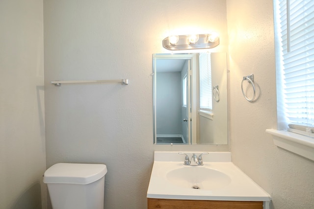 bathroom featuring a healthy amount of sunlight, toilet, and vanity