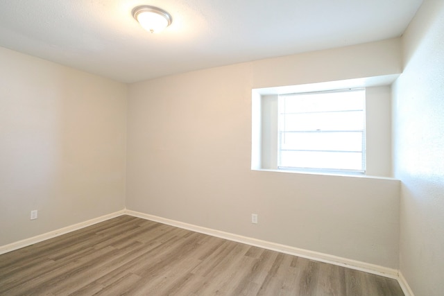 empty room featuring baseboards and wood finished floors