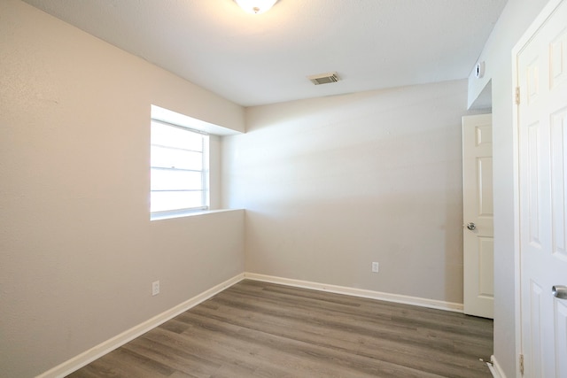 unfurnished room with visible vents, baseboards, and wood finished floors