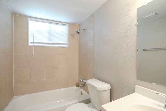 full bathroom with vanity, visible vents, bathing tub / shower combination, toilet, and a textured wall