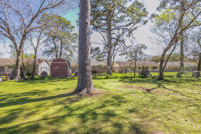 view of yard with a residential view, an outbuilding, a barn, and fence