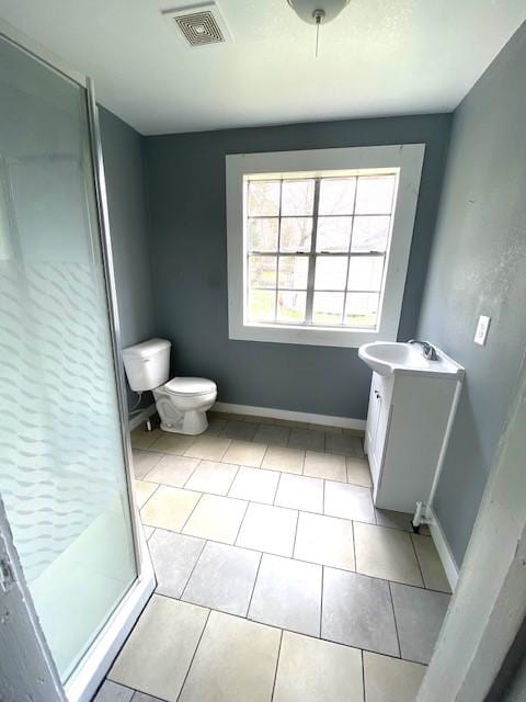 full bath featuring tile patterned flooring, visible vents, baseboards, toilet, and a stall shower