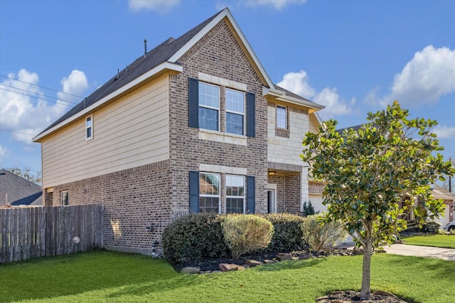 exterior space with brick siding, a lawn, and fence