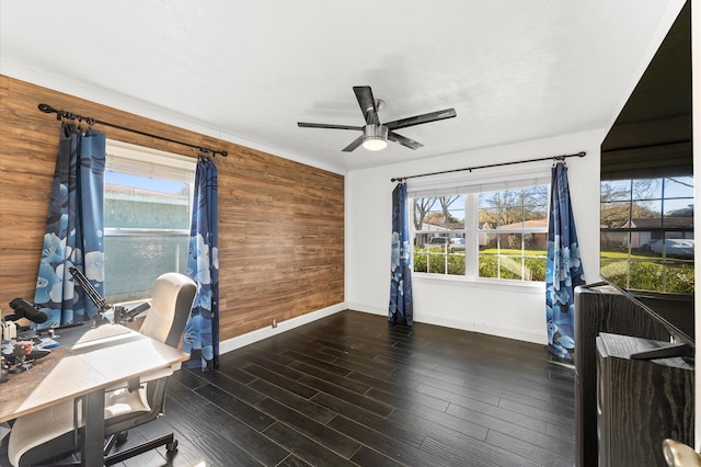 office area featuring wooden walls, baseboards, ceiling fan, and wood finished floors